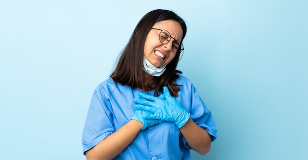 Chirurg vrouw over blauwe muur met een pijn in het hart