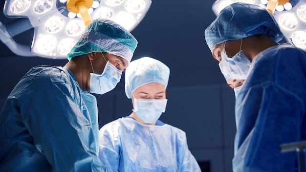 Chirurgie, geneeskunde en mensenconcept - groep chirurgen bij verrichting in operatiekamer bij het ziekenhuis