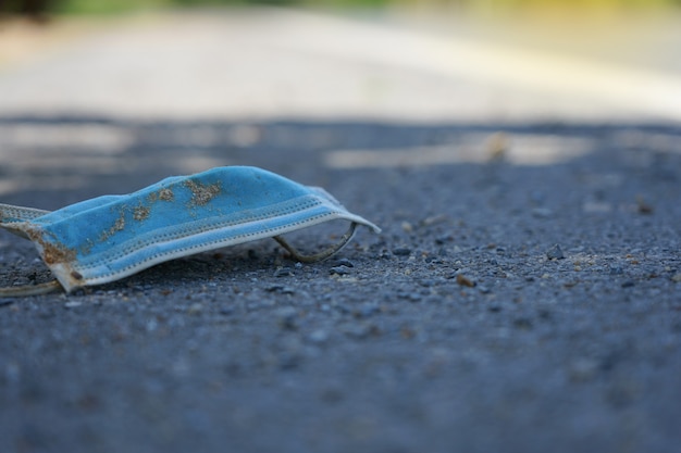 Chirurgisch masker na gebruik viel op de weg gevaarlijk en vies op straat