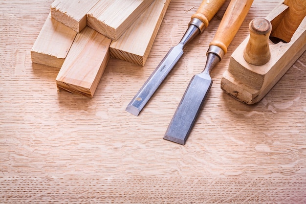 Chisels plane planks on wooden board