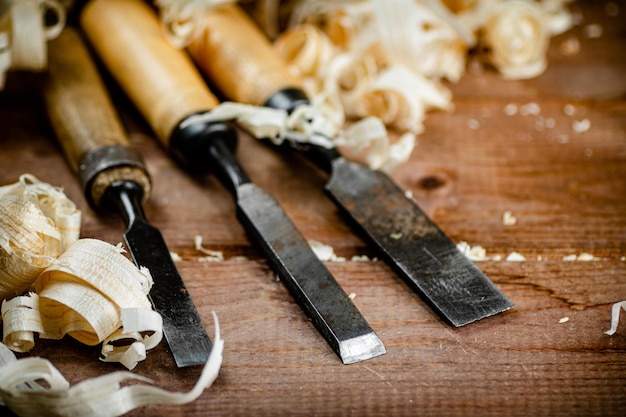 Foto scalpelli con trucioli di legno su fondo in legno