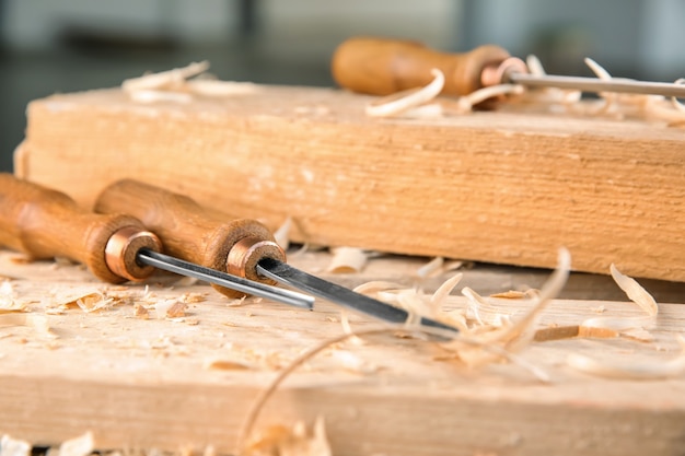 Chisels, wooden boards and sawdust in carpenter's workshop