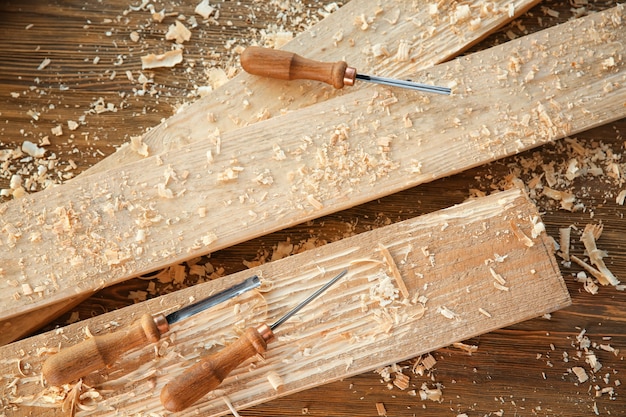 Стамески, деревянные доски и опилки в столярной мастерской