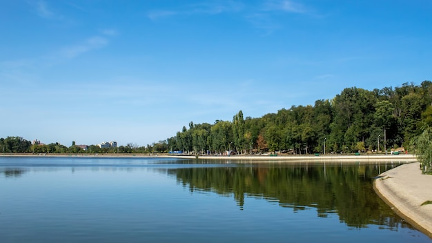CHISINAU, MOLDAVIË - SEPTEMBER 20, 2020: Valea Morilor-park met wandelende mensen, meer met groene, weelderige bomen weerspiegeld in het water