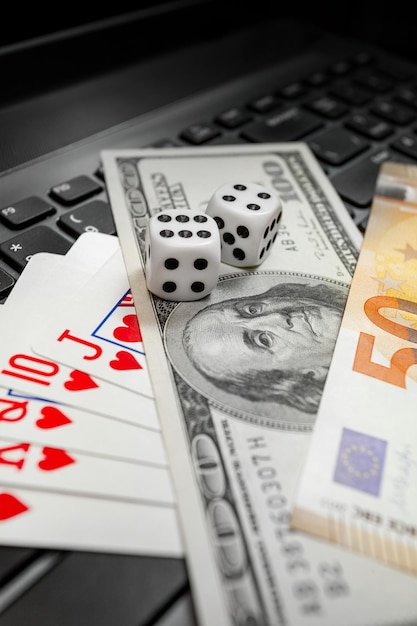 Chisinau, Moldova - 20. 12. 2020 dice, playing cards on laptop keyboard dollars and euro bills