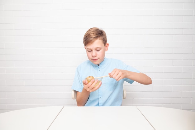 Chisinau, MOLDOVA - 29 June 2022. European teenager is tasting honey