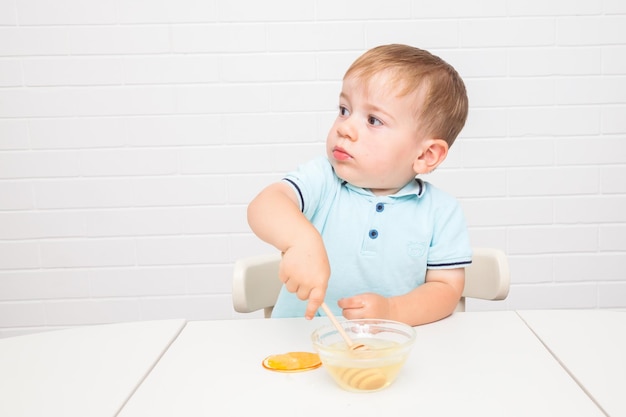 Chisinau, MOLDOVA - 29 June 2022. Little European boy tastes honey