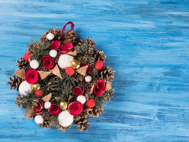 Photo chistmas door decoration with small gift boxes on blue wooden background. greeting symbol.