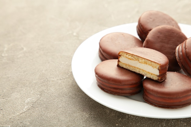 Choco pie chocolate coated snacks in plate on grey background. Top view