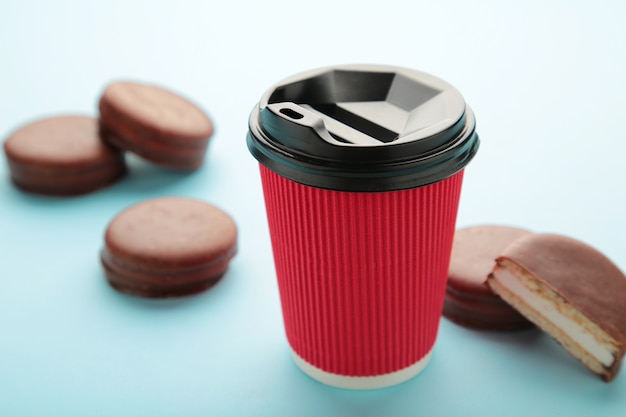 Choco pie chocolate coated snacks with cup of coffee on blue background. Top view