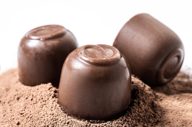 Chocolade bonbons en cacaopoeder geïsoleerd op een witte achtergrond