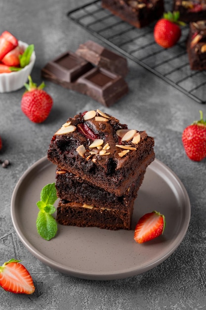 Chocolade brownie stukjes met noten, aardbei en ijs op een bord Selectieve aandacht