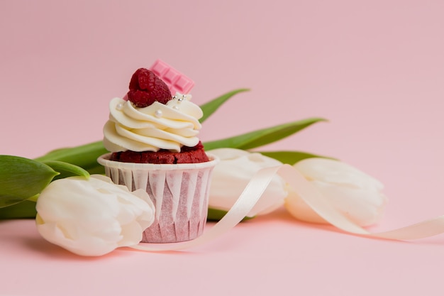 chocolade cupcake en witte tulpen op een roze ruimte