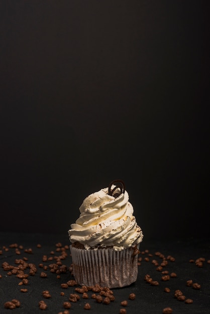 Foto chocolade cupcake met sprinkles op zwarte achtergrond