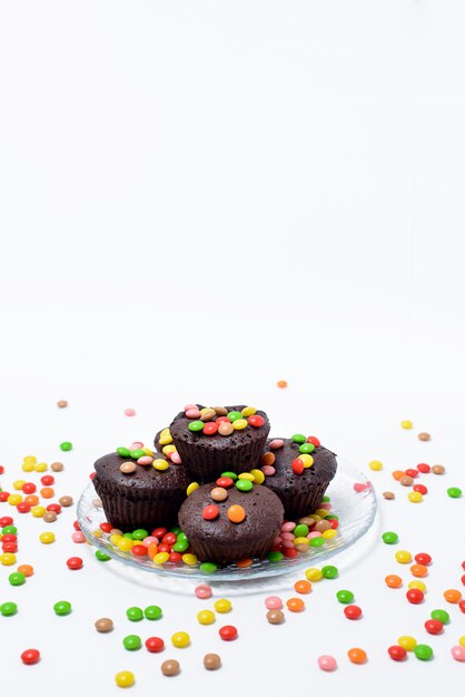 Chocolade cupcakes en een selectie van snoep op een zwarte ondergrond