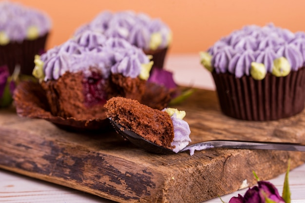 Chocolade cupcakes op een houten tafel met bloemen uit de cremama, met fruit jam binnen.