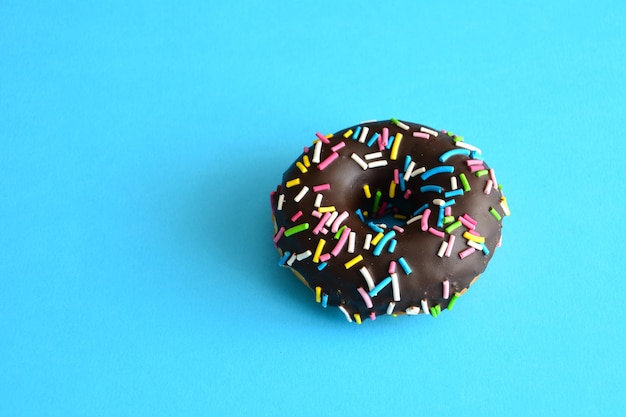 chocolade donut geïsoleerd op een blauwe achtergrond, close-up