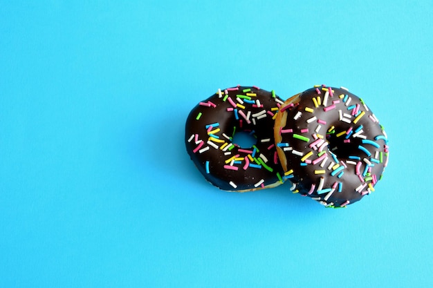 chocolade donuts met hagelslag geïsoleerd op blauwe achtergrond, close-up