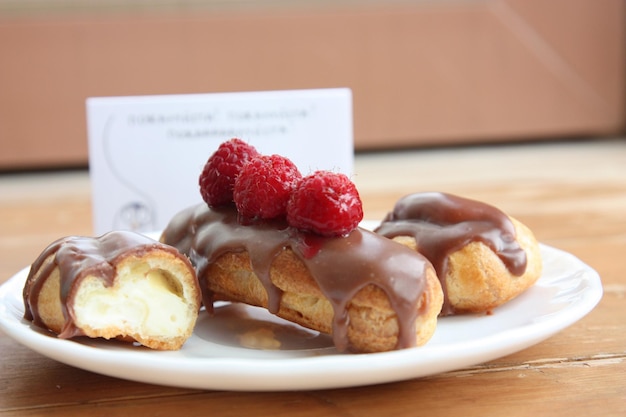 Chocolade eclairs met frambozen op bord