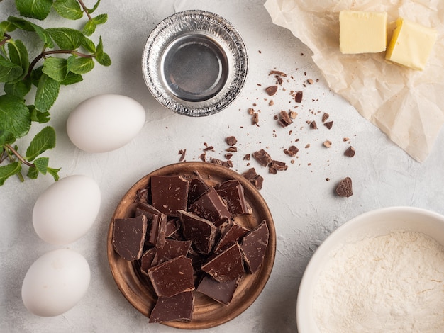 Chocolade, eieren, boter, meel op tafel. Bovenaanzicht.