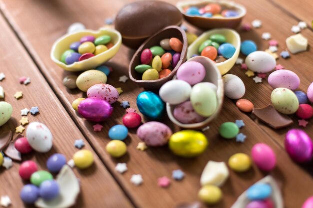 Foto chocolade eieren en snoep druppels op houten tafel