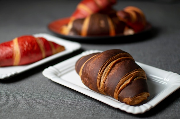 Chocolade en rode croissants liggen op borden op een grijze doek close-up broodjes