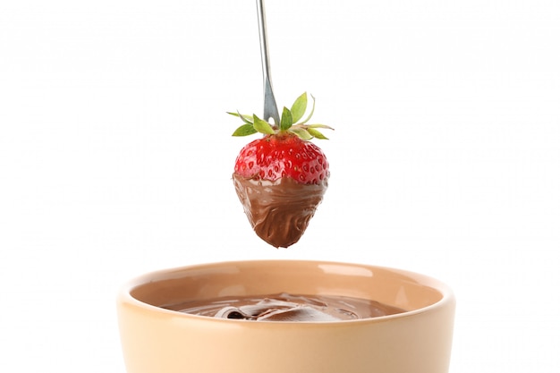 Chocolade fondue. Aardbei in chocolade die op witte achtergrond wordt geïsoleerd