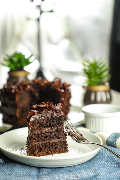 Foto chocolade fudge cake met vork en mes geserveerd in plaat op voedsel tafelblad weergave café bak dessert