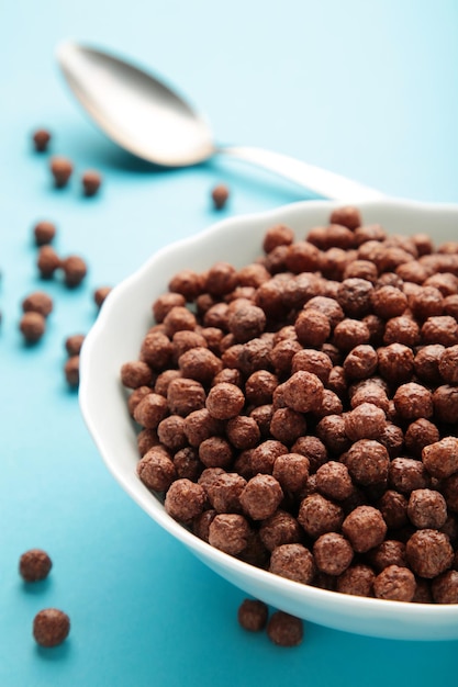Chocolade granen maïs ballen in een blauwe kom op een blauwe achtergrond