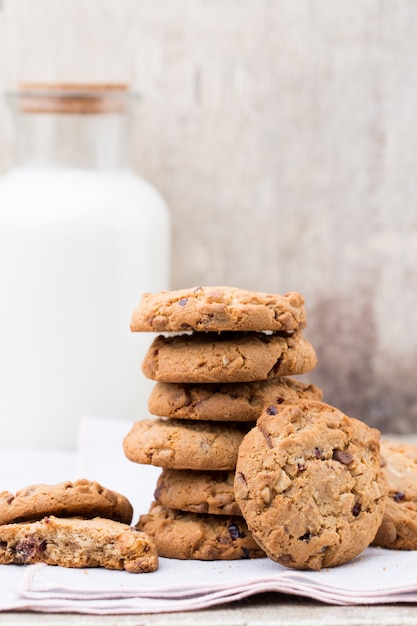 Chocolade havermout chip cookies met melk op de rustieke houten tafel.