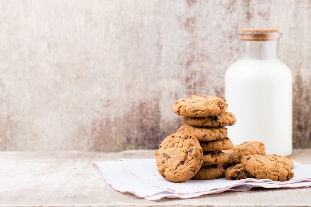 Chocolade havermout chip cookies met melk op rustieke houten tafel.