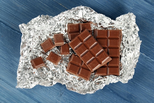 Chocolade in folie op houten tafel close-up