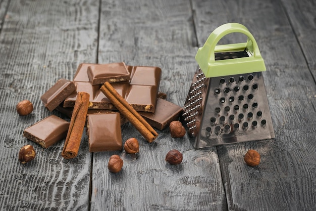 Chocolade kaneelnoten en een rasp op een houten tafel