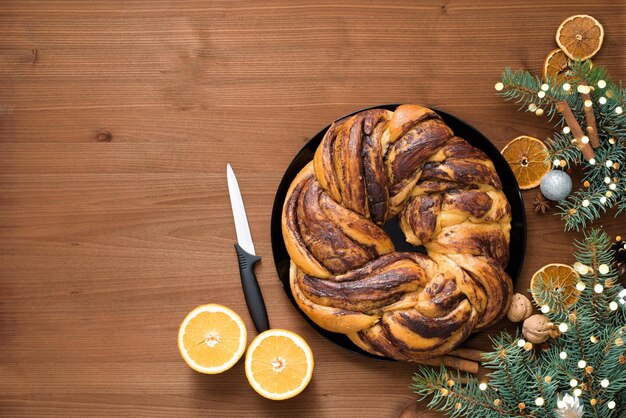 Foto chocolade kerstgrootmoeder in de vorm van een krans met sinaasappelsiroop op een bord in stukken gesneden