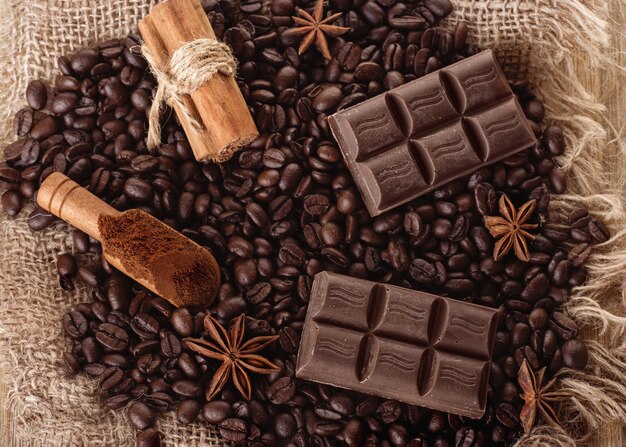 Chocolade, koffiebonen, anijs op houten achtergrond