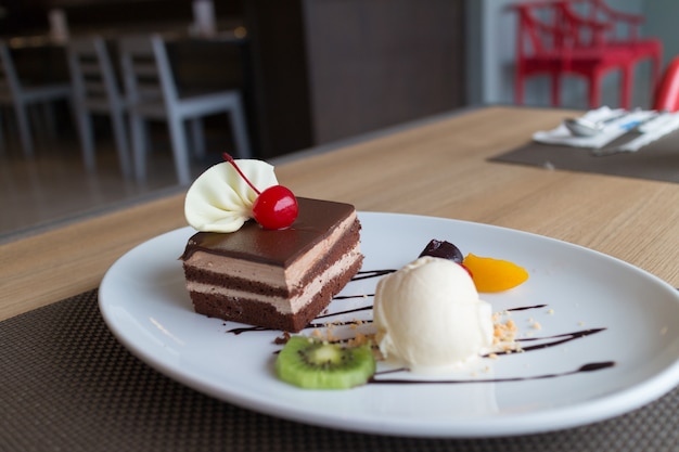 Chocolade laag cake en vanille-ijs met vers fruit en kersen