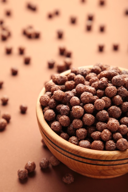 Chocolade maïs ballen in houten kom op bruine achtergrond