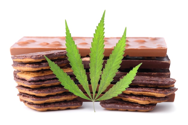 Chocolade met marihuana-extract, chocoladekoekjes met cbd-gehalte. chocoladerepen met noten en cbd-cannabisgehalte, groen hennepblad.