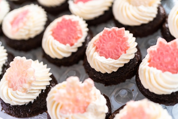 Chocolade mini cupcakes met Italiaanse buttercream frosting gedecoreerd met glittery chocolade sneeuwvlokken.