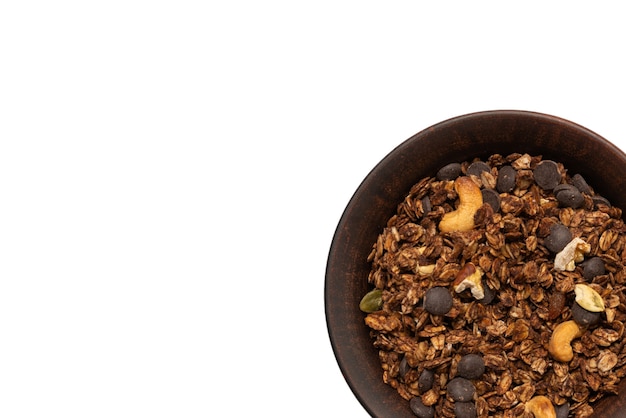 Chocolade muesli granen met noten in een kom oppervlak. Geïsoleerd op een witte achtergrond.