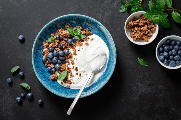 Chocolade muesli met witte yoghurt en verse bosbessen in een kom gezond voedsel voor ontbijt bovenaanzicht