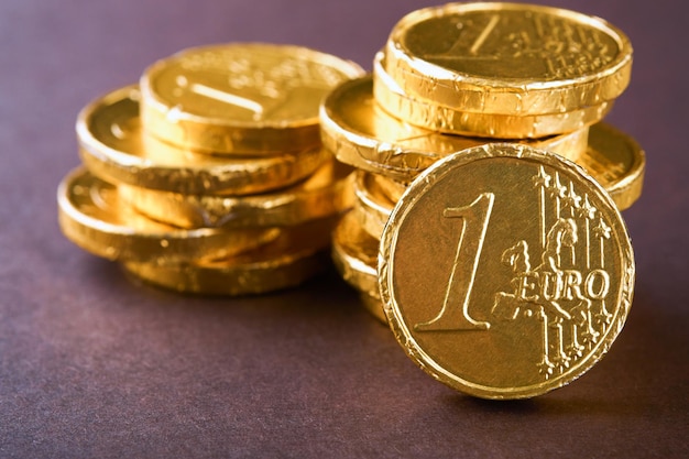 Chocolade munt Achtergronden van chocolade Euro munt geld op bruine achtergrond Euromunten gestapeld op elkaar in verschillende posities Groep munten Mock up