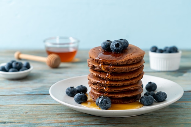 chocolade pannenkoek stapel met bosbessen en honing op plaat