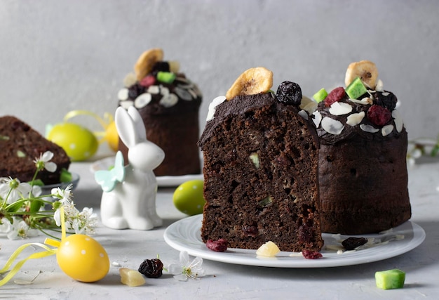 Chocolade pasen cakes met gekonfijte vruchten en kleurrijke eieren op een grijze achtergrond pasen lente stilleven