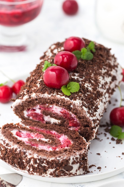 Chocolade roll cake met room en kersen. Zomer dessert met bessen