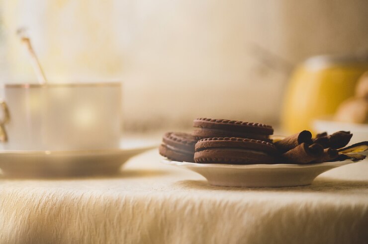 Chocolade ronde koekjes met een laagje en vulling op een bord versierd met kaneel
