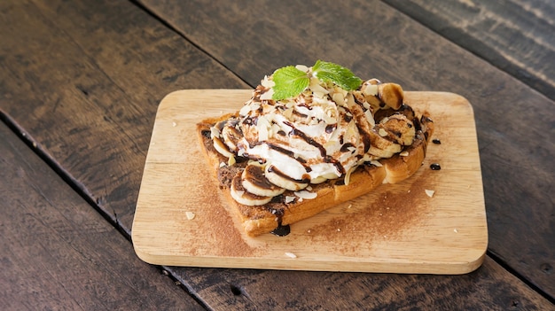 Chocolade, slagroom en banaan op een brood.