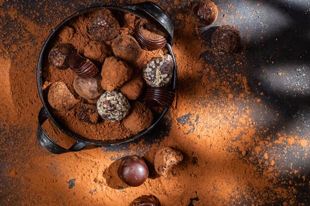 Chocolade snoepjes in een bord op een donkere achtergrond Cacao
