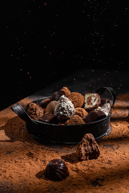 Chocolade snoepjes in een bord op een donkere achtergrond Cacao