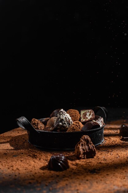 Chocolade snoepjes in een bord op een donkere achtergrond Cacao